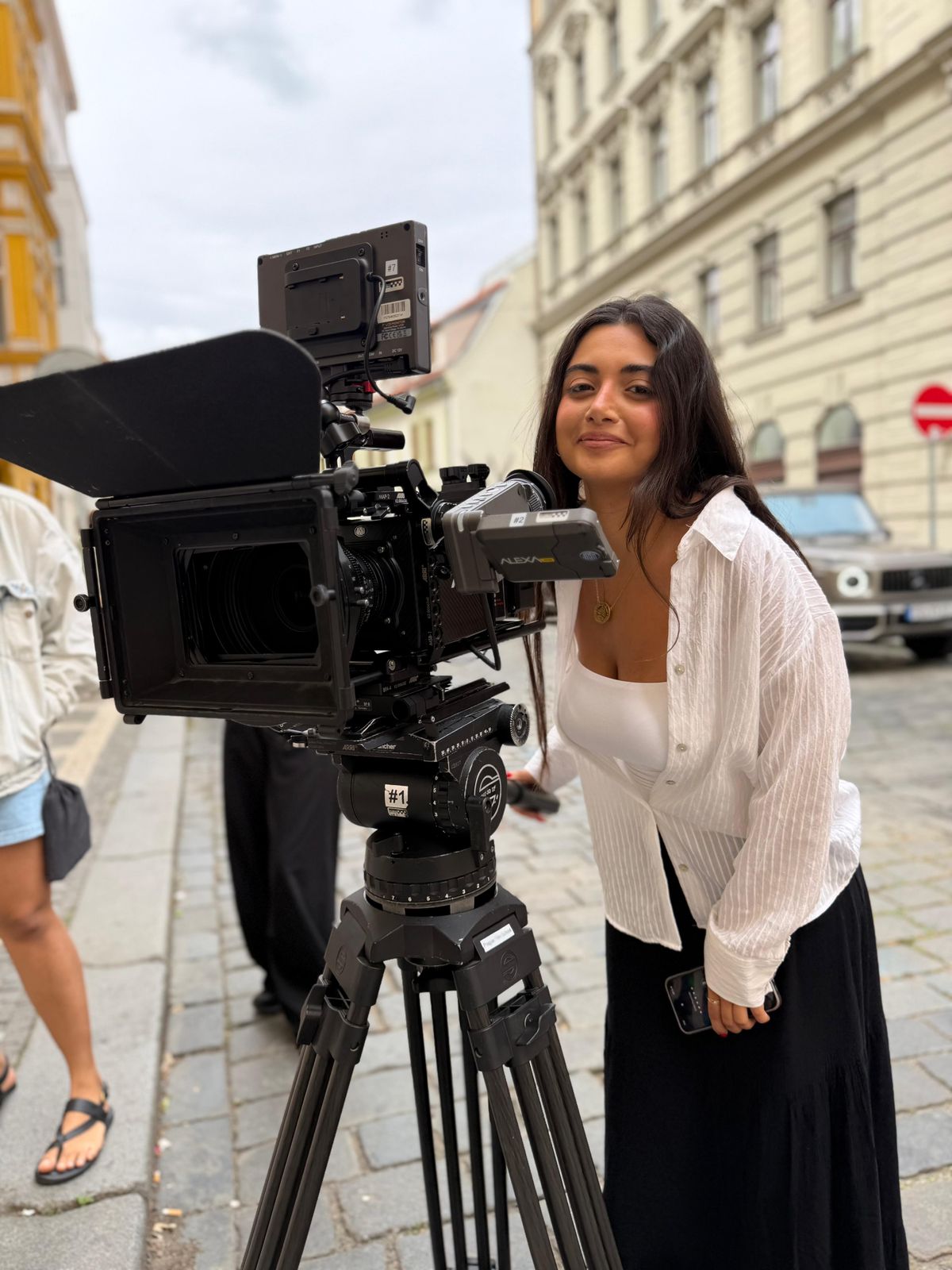 Tracy Greige working beside a cinema camera on a Prague street