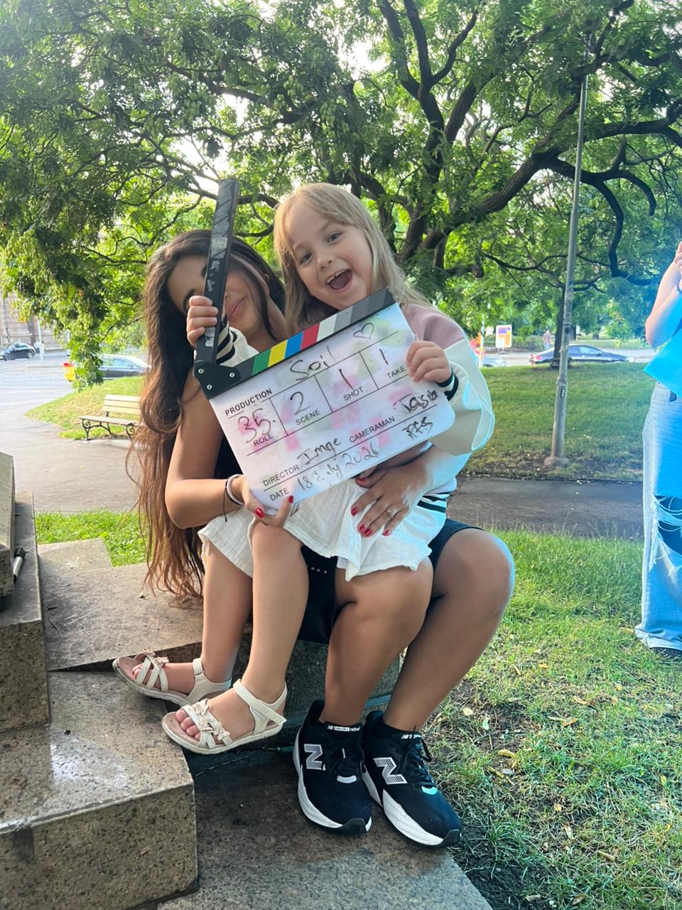 Tracy Greige and a young performer holding the Soi clapperboard