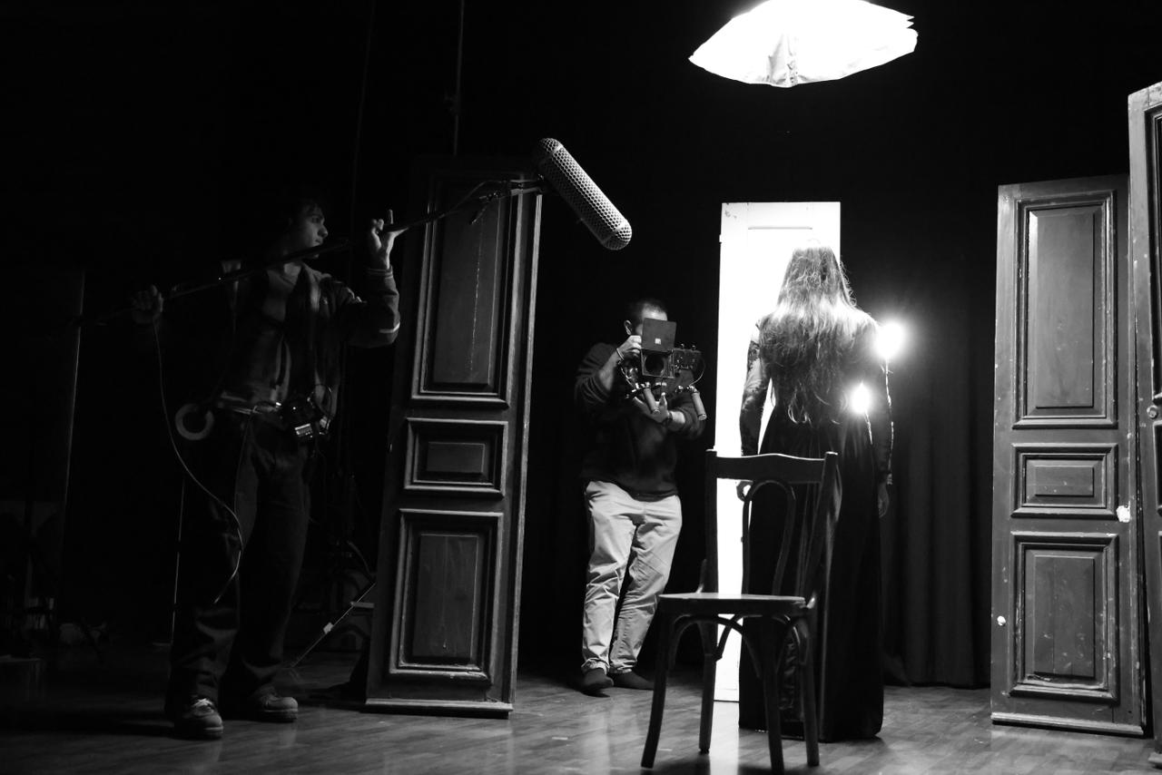 Black-and-white stage setup with camera and boom microphone